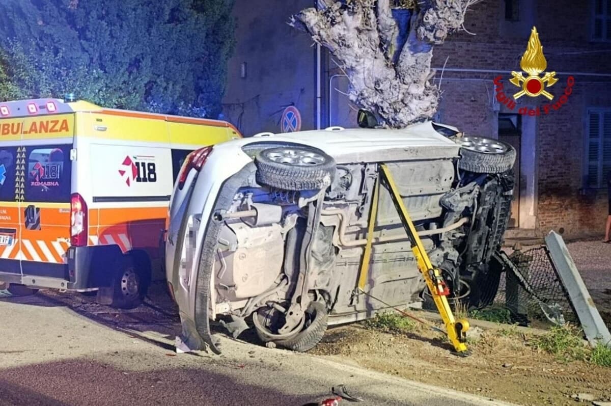 Urta un'auto in sosta e si ribalta al centro della strada: conducente incastrato nel veicolo