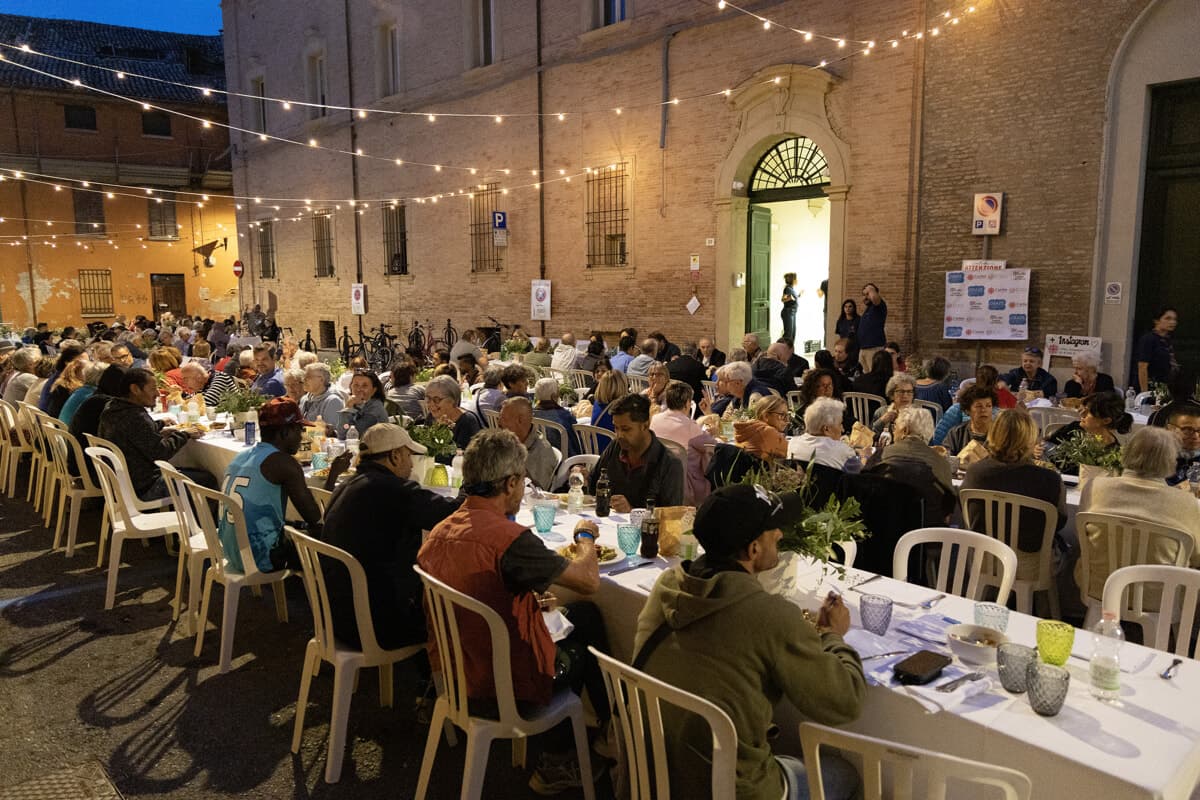 Una tavola per 180 persone in via dei Mille: la Caritas festeggia in strada la solidarietà e la comunità